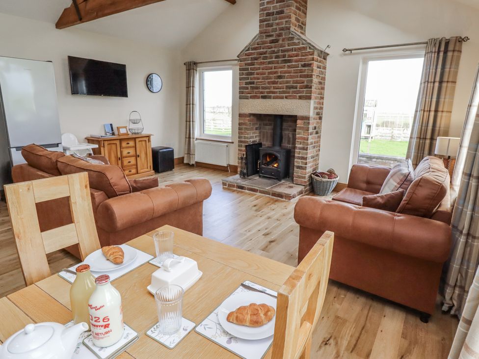 A living room with a sofa and a fireplace at Grey Croft in Embleton
