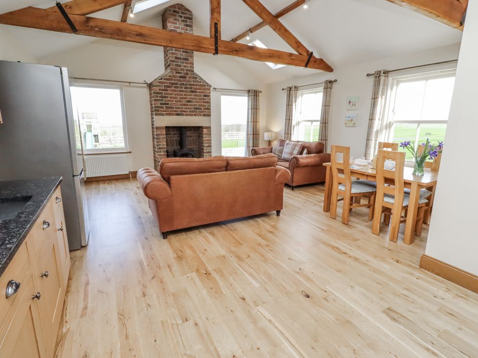A living room with a sofa and dining table at Grey Croft in Embleton