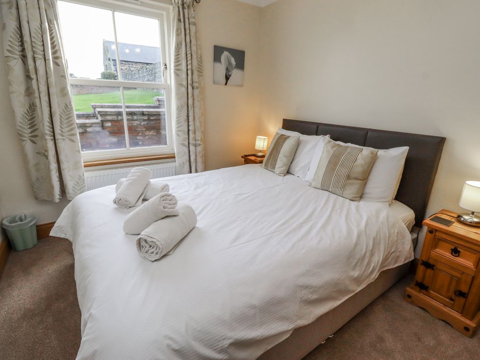 A bedroom with a bed and bedside tables at Grey Croft Embleton