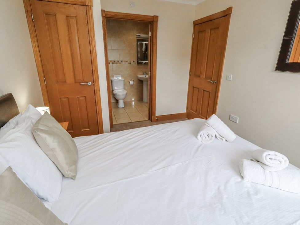 A bedroom with a bed and an adjoining bathroom at Grey Croft in Embleton