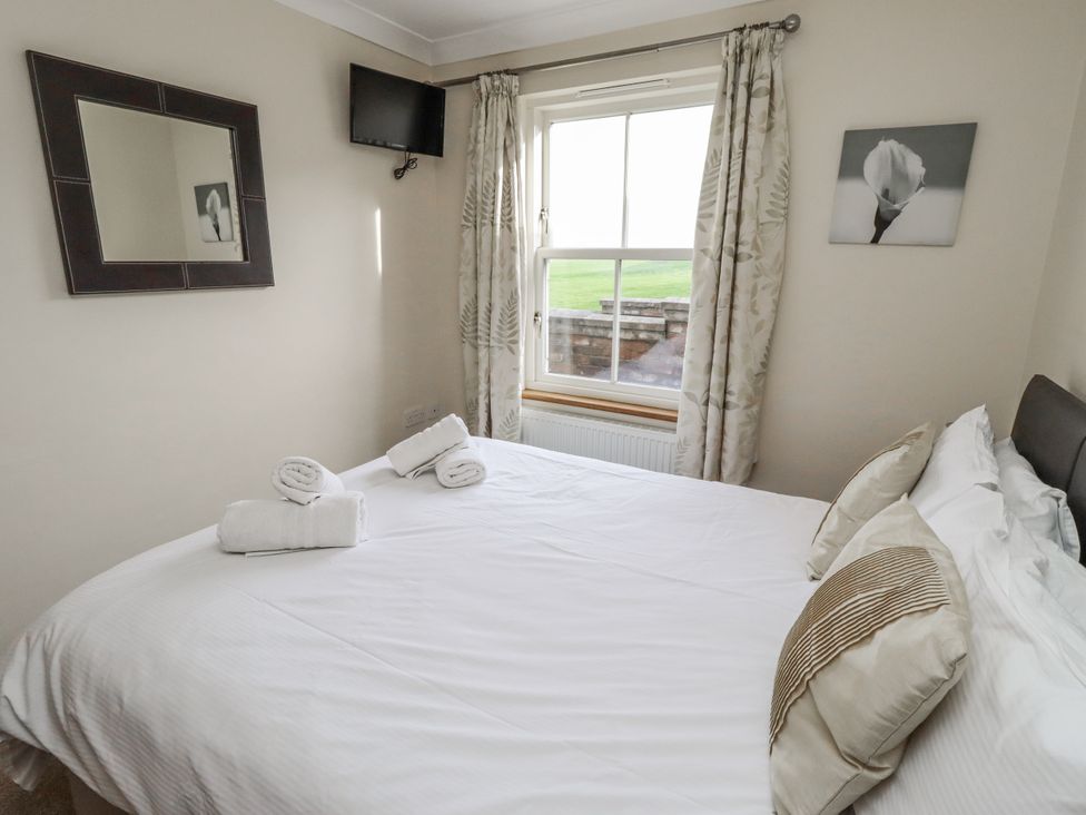 A bedroom with a bed and decorative items at Grey Croft in Embleton