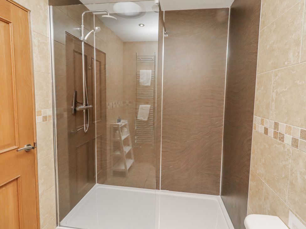 A bathroom with a shower and towel rail at Grey Croft in Embleton