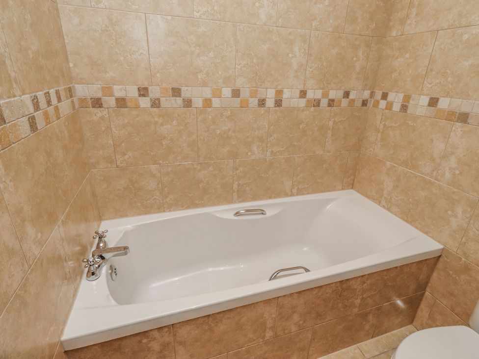 A bathtub with a tap in a bathroom at Grey Croft in Embleton
