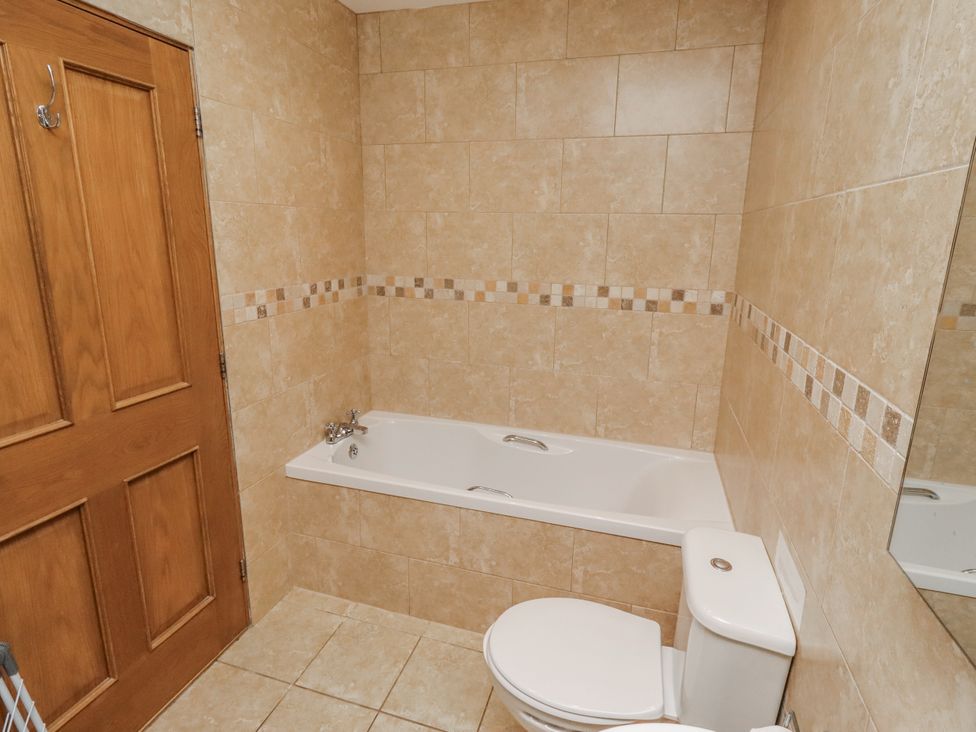 A bathroom with a bathtub and toilet at Grey Croft in Embleton