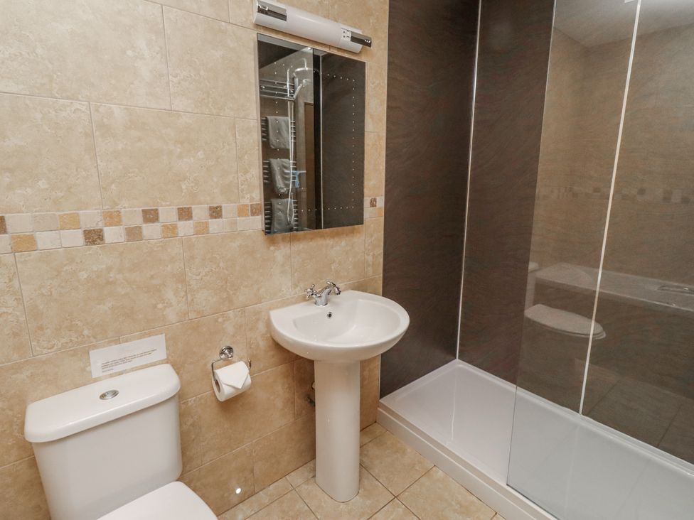 A bathroom featuring a sink and toilet with a shower at Grey Croft in Embleton