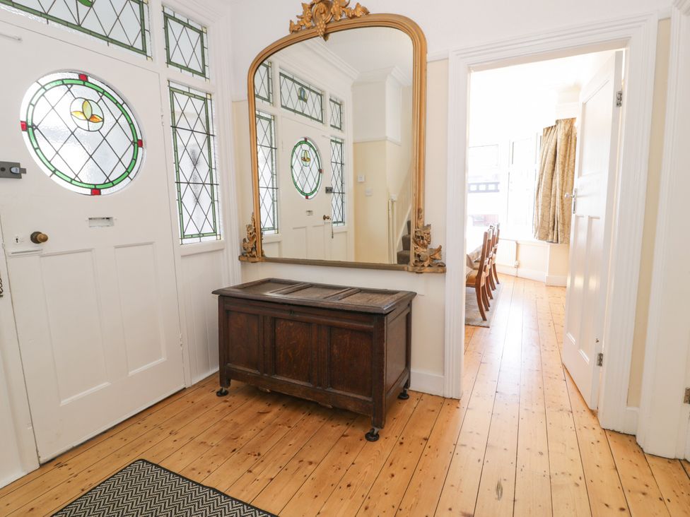 A hallway with a console table and a mirror at Meadway House Rhos-on-Sea