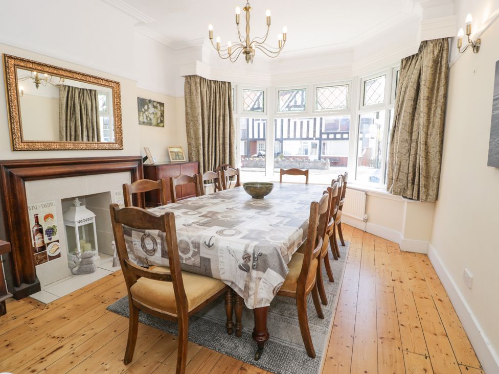 A dining room with a large table and chairs at Meadway House in Rhos-on-Sea