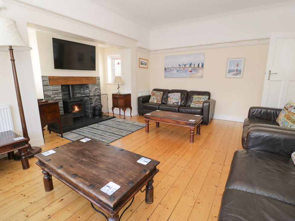 A living room with sofas, a coffee table and a television at Meadway House in Rhos-on-Sea