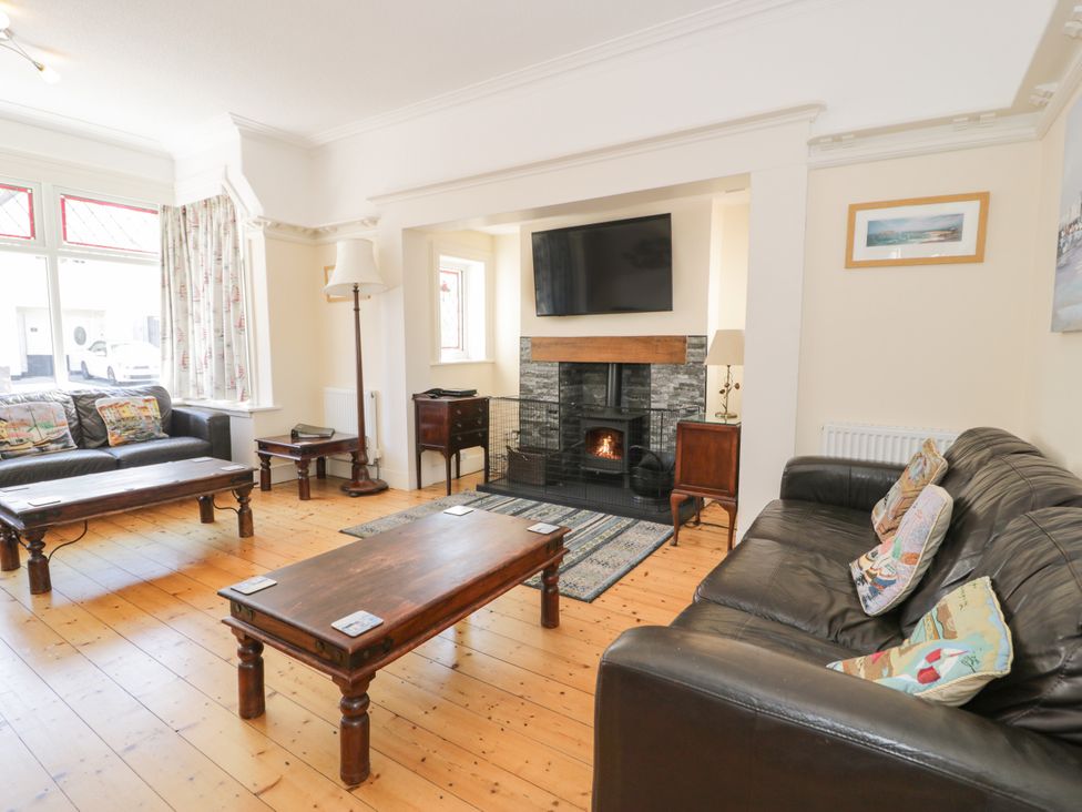A living room with a television and fireplace at Meadway House in Rhos-on-Sea