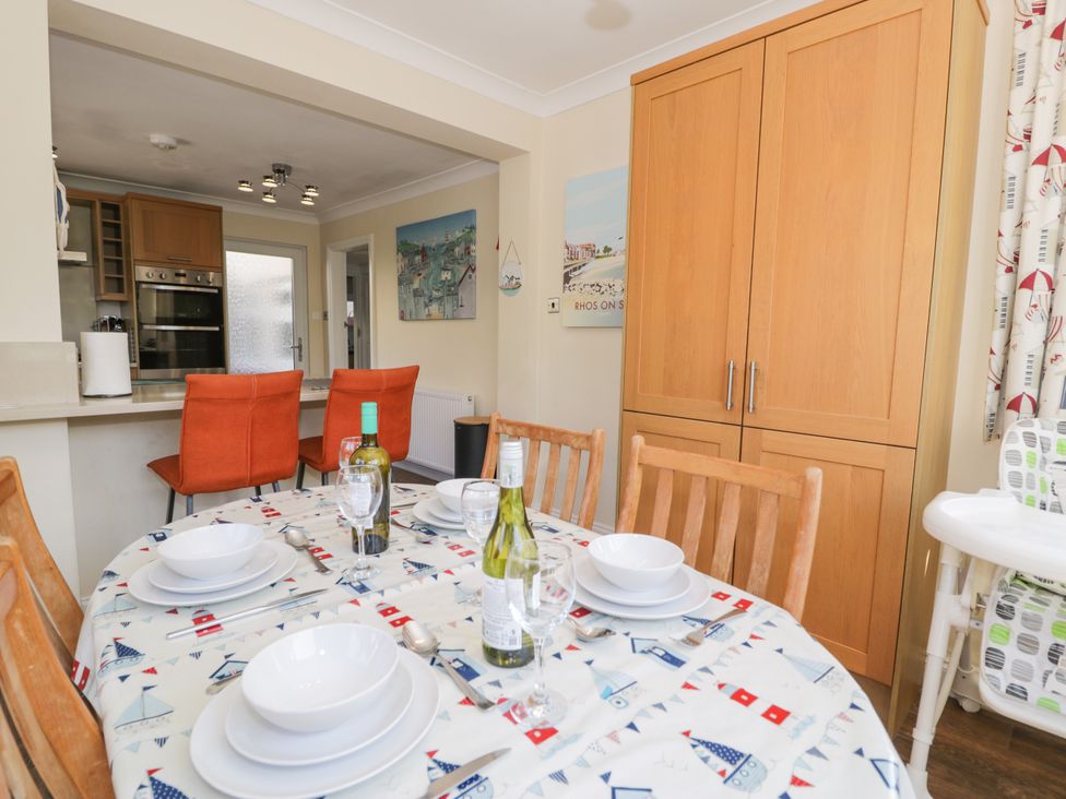 A dining room with a table set for meals in Meadway House Rhos-on-Sea