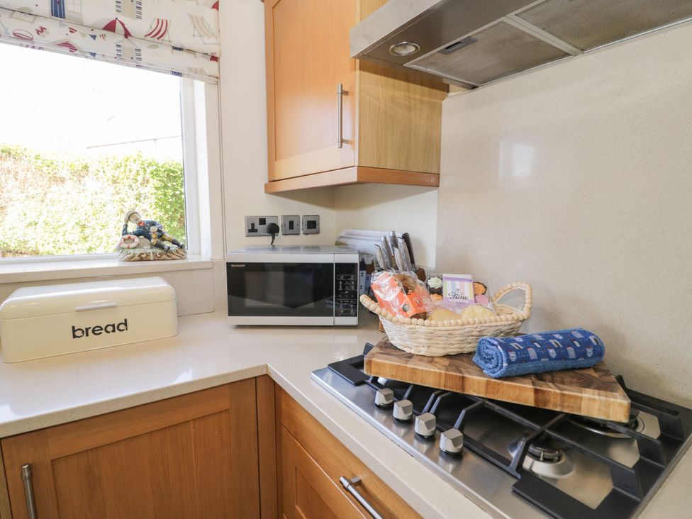 A kitchen with a microwave and bread box at Meadway House Rhos-on-Sea