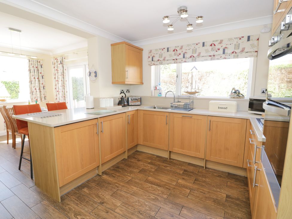 A kitchen with cabinets and a sink at Meadway House in Rhos-on-Sea