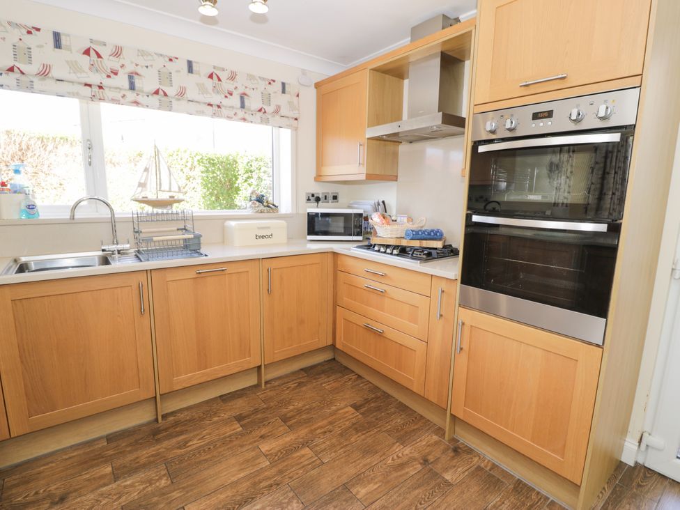 A kitchen with various appliances and cabinets at Meadway House Rhos-on-Sea
