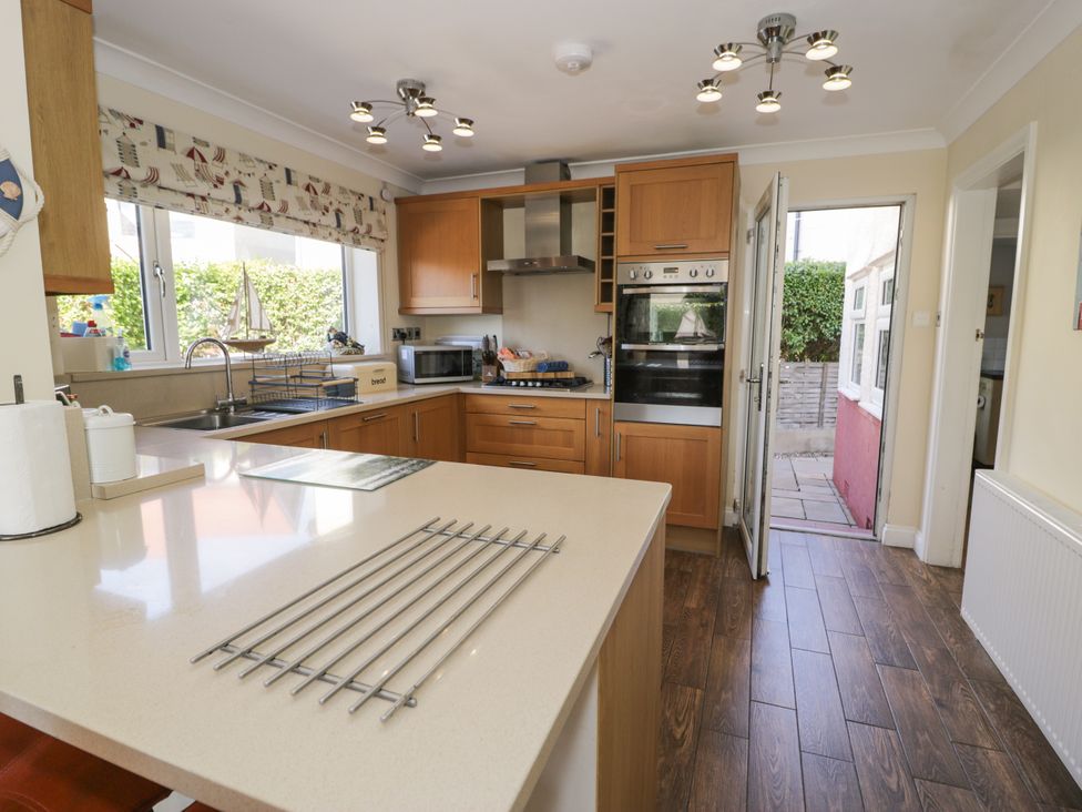A kitchen with wooden cabinets and appliances at Meadway House in Rhos-on-Sea