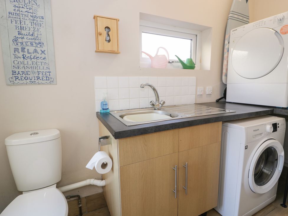 A laundry room with a sink and washing machine at Meadway House, Rhos-on-Sea