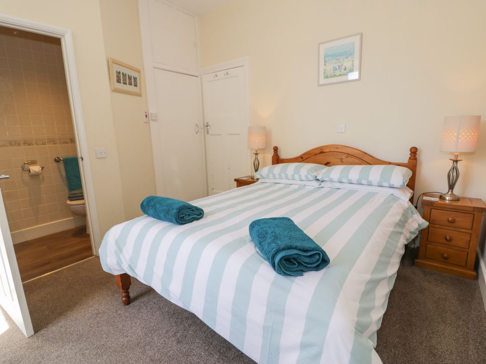 A bedroom with a bed and bathroom access at Meadway House in Rhos-on-Sea