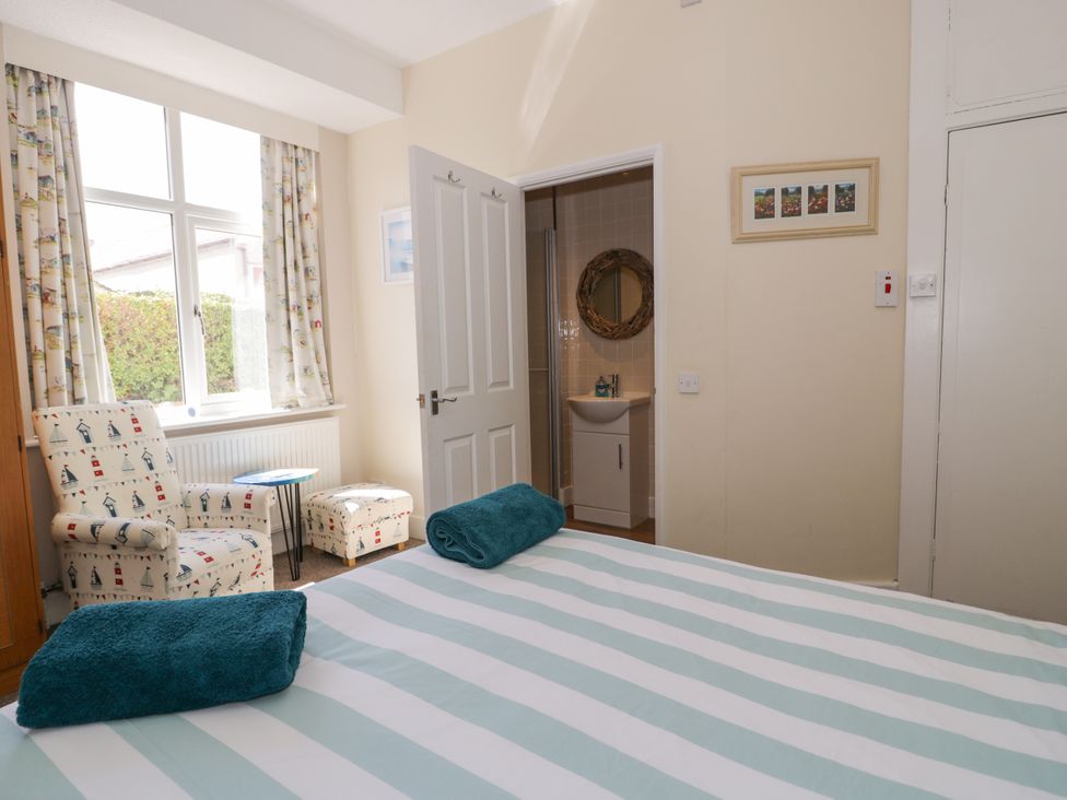 A bedroom with a bed and chairs at Meadway House in Rhos-on-Sea
