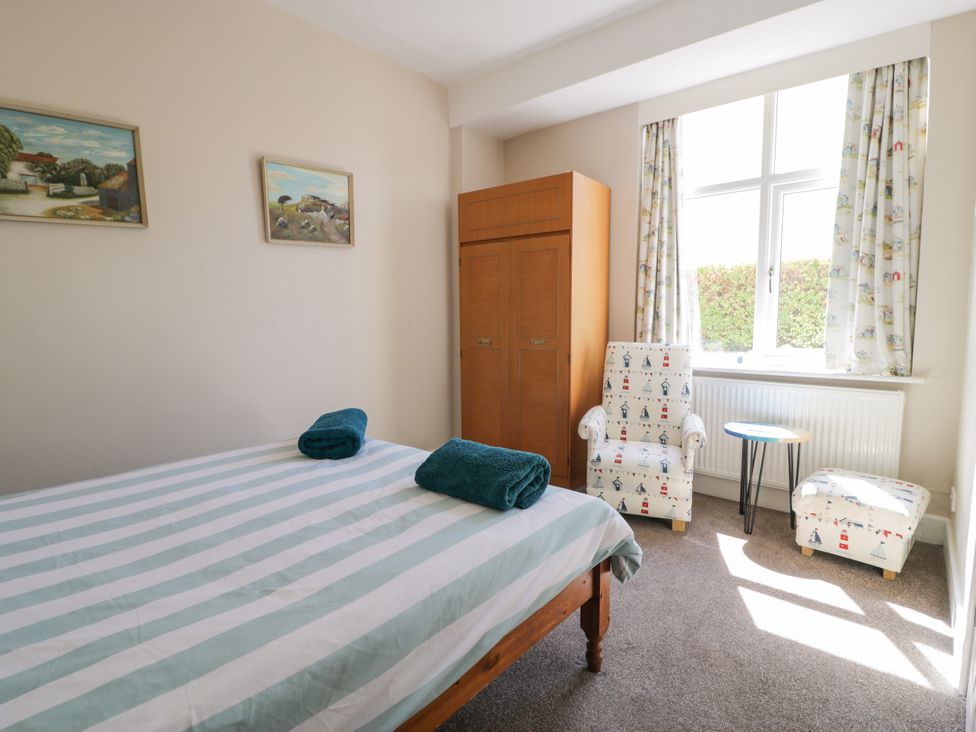 A bedroom with a bed and chairs at Meadway House in Rhos-on-Sea