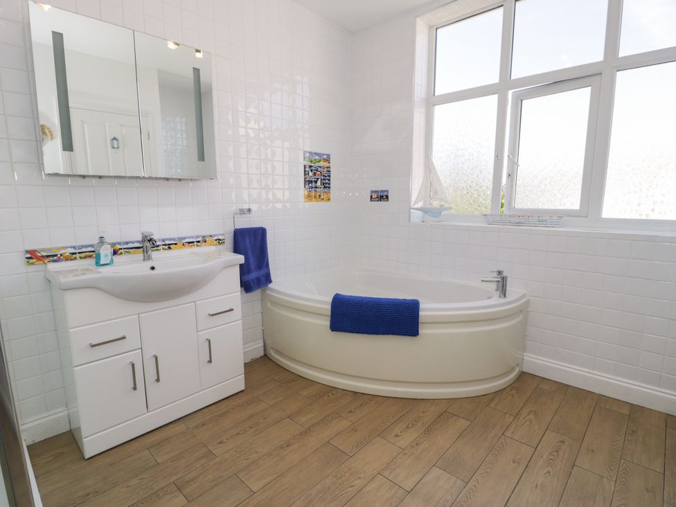A bathroom with a bathtub and sink at Meadway House in Rhos-on-Sea