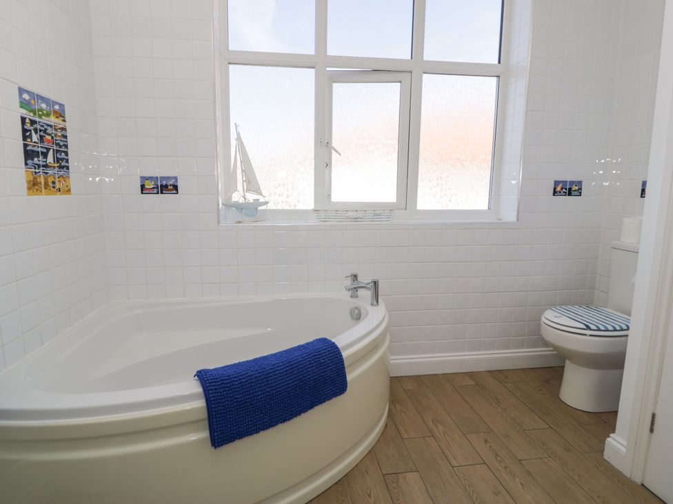 A bathroom with a bathtub and toilet at Meadway House in Rhos-on-Sea