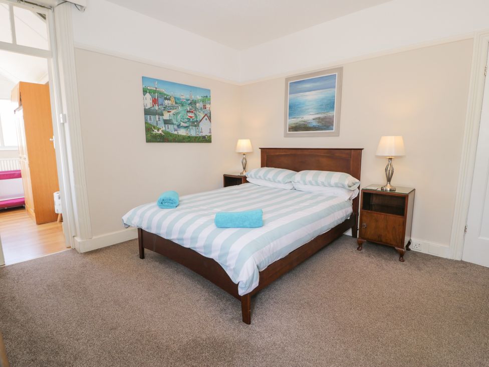 A bedroom with a bed and nightstand at Meadway House in Rhos-on-Sea