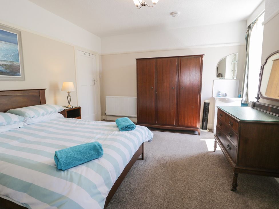 A bedroom with a bed, wardrobe, and dresser at Meadway House in Rhos-on-Sea