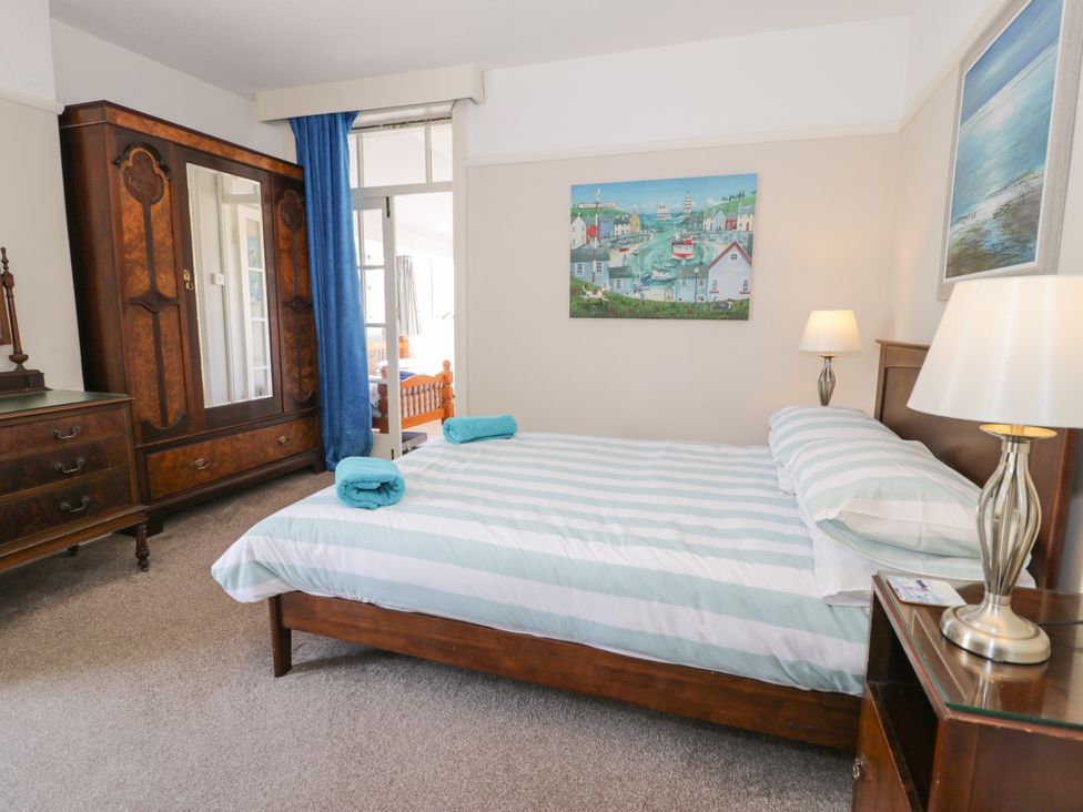 A bedroom with a bed and wardrobe at Meadway House Rhos-on-Sea