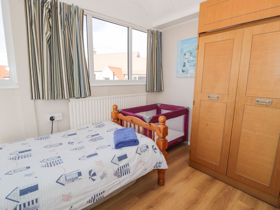 A bedroom with a bed and wardrobe at Meadway House in Rhos-on-Sea