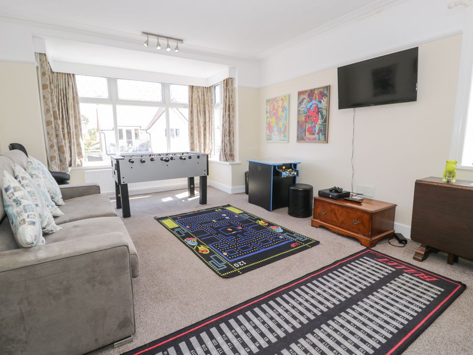 A snug room with a foosball table and a television at Meadway House in Rhos-on-Sea