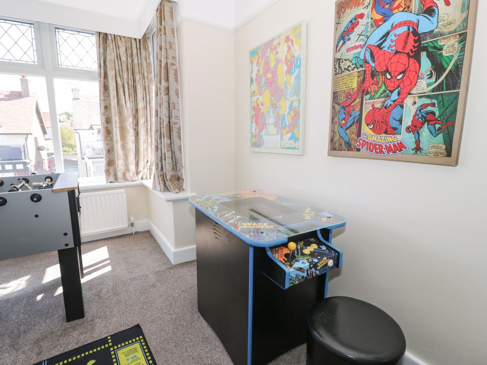 A game room with a foosball table and arcade cabinet at Meadway House Rhos-on-Sea