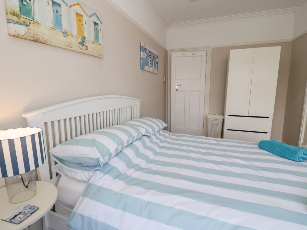 A bedroom with a bed and lamp at Meadway House in Rhos-on-Sea