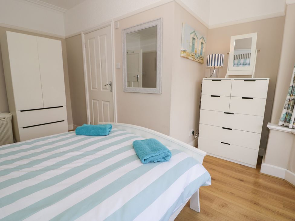 A bedroom with a bed and wardrobe at Meadway House Rhos-on-Sea