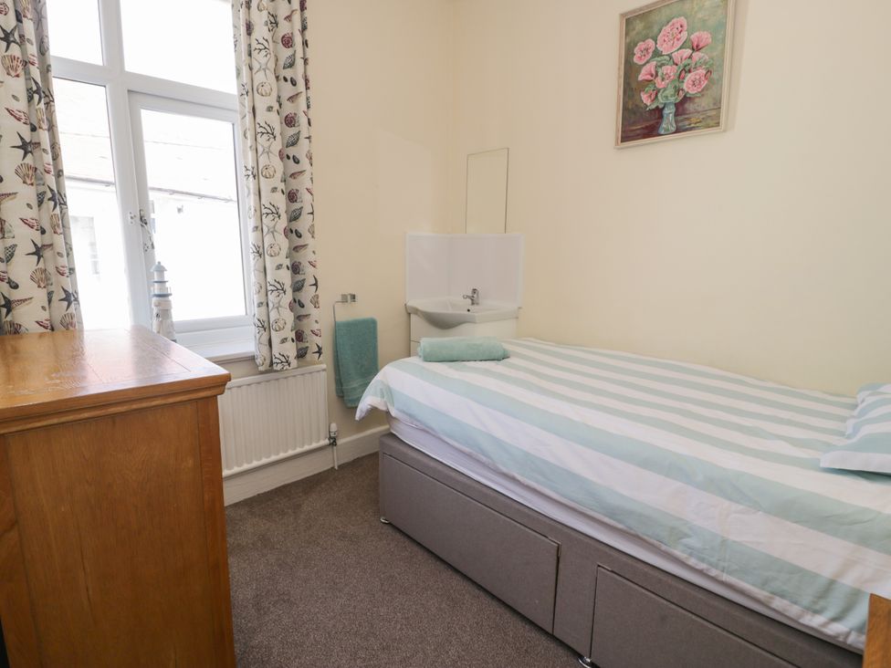 A bedroom with a bed and wardrobe at Meadway House in Rhos-on-Sea
