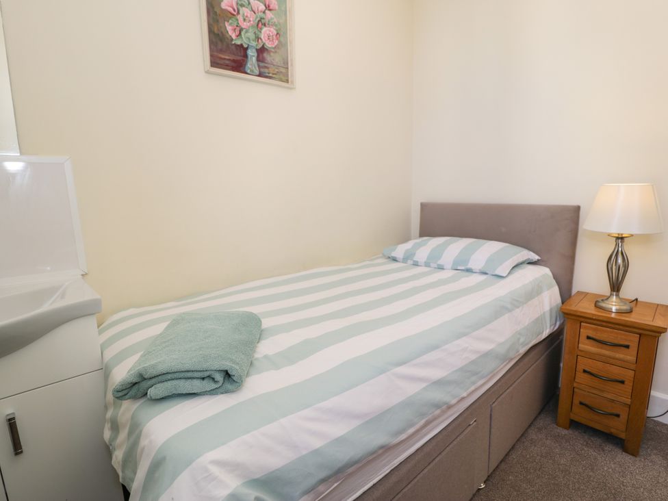 A bedroom with a bed and a sink at Meadway House in Rhos-on-Sea