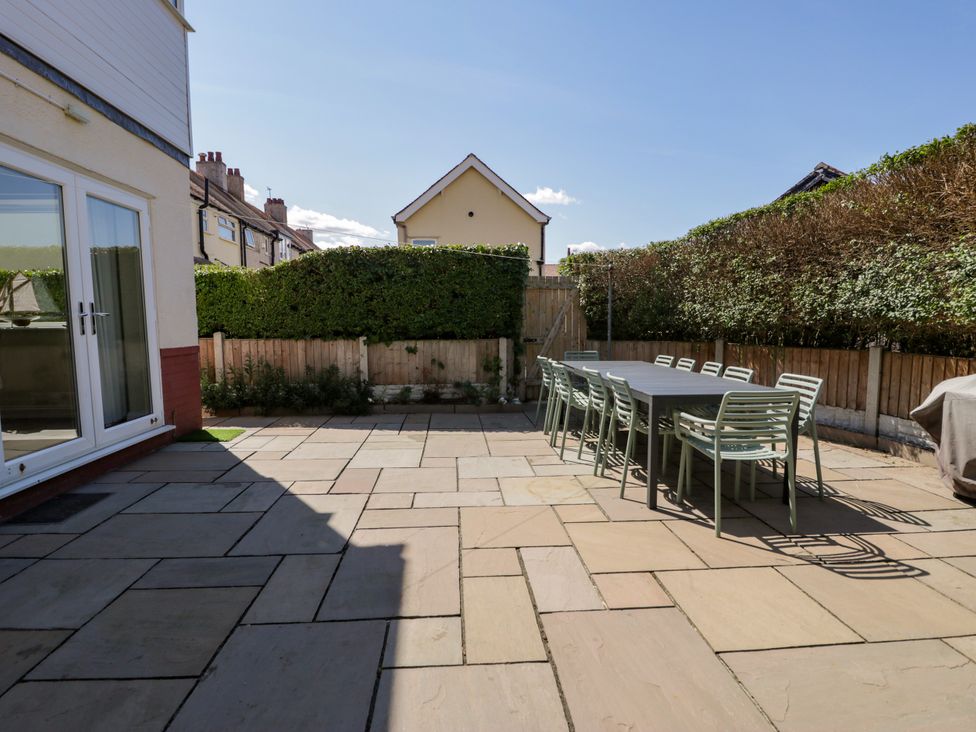 A garden with a table and chairs on a patio at Meadway House in Rhos-on-Sea