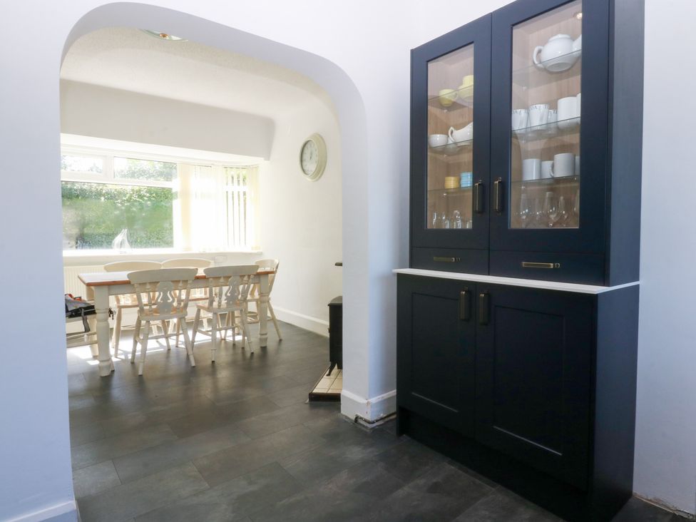A dining room with a table and chairs at Monarfon Benllech near Red Wharf Bay