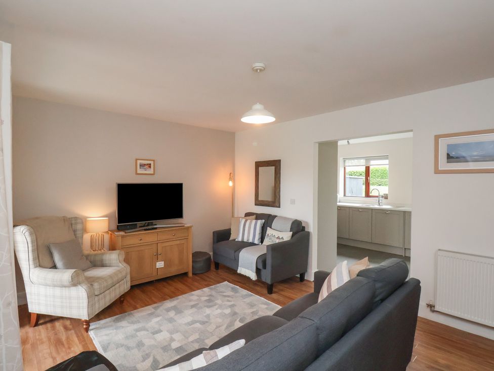 A living room with sofas armchair television and a rug at Buffers in Whitby