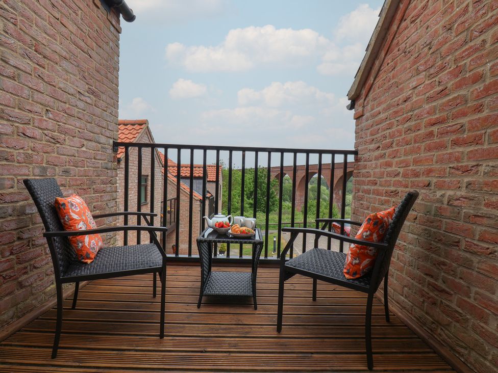 A small balcony with two chairs and a table set with tea and pastries at Buffers in Whitby