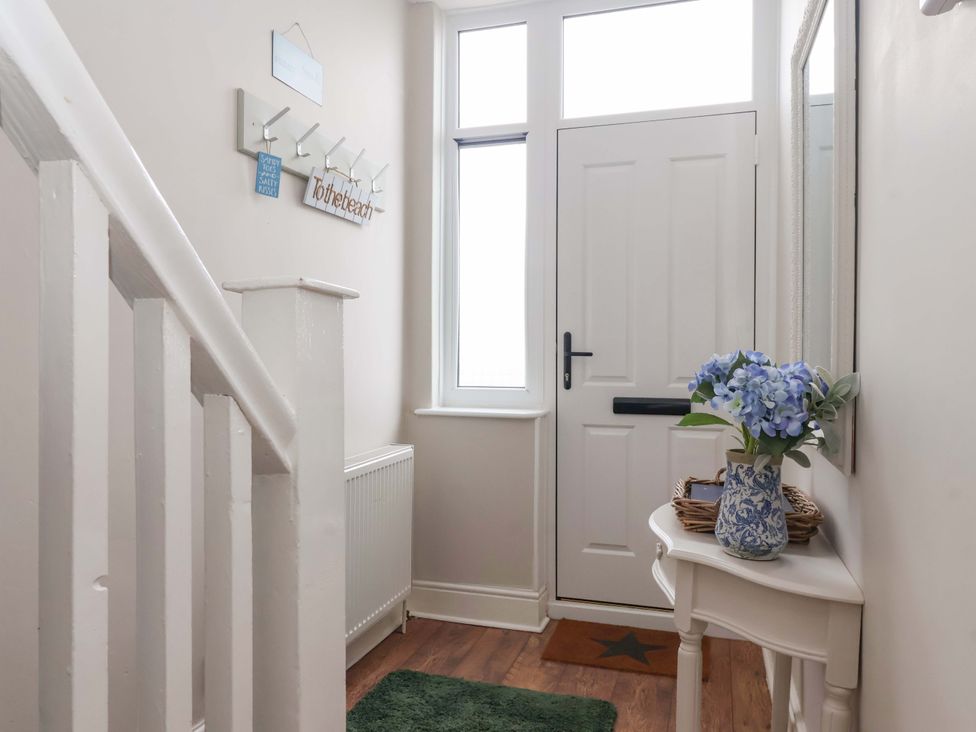 A hallway with a table and flowers at Sea View House in Hornsea