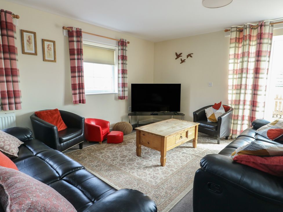 A living room with sofa and coffee table at Ty Ni Caeathro near Caernarfon