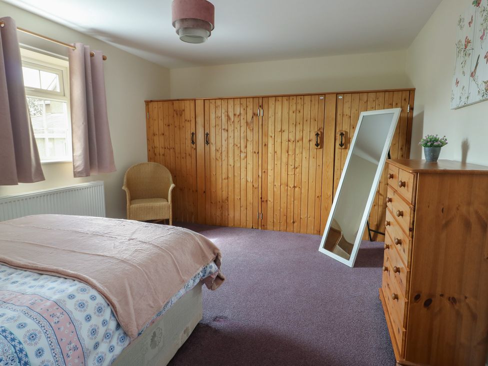 A bedroom with a bed and wooden furniture at Ty Ni in Caeathro near Caernarfon