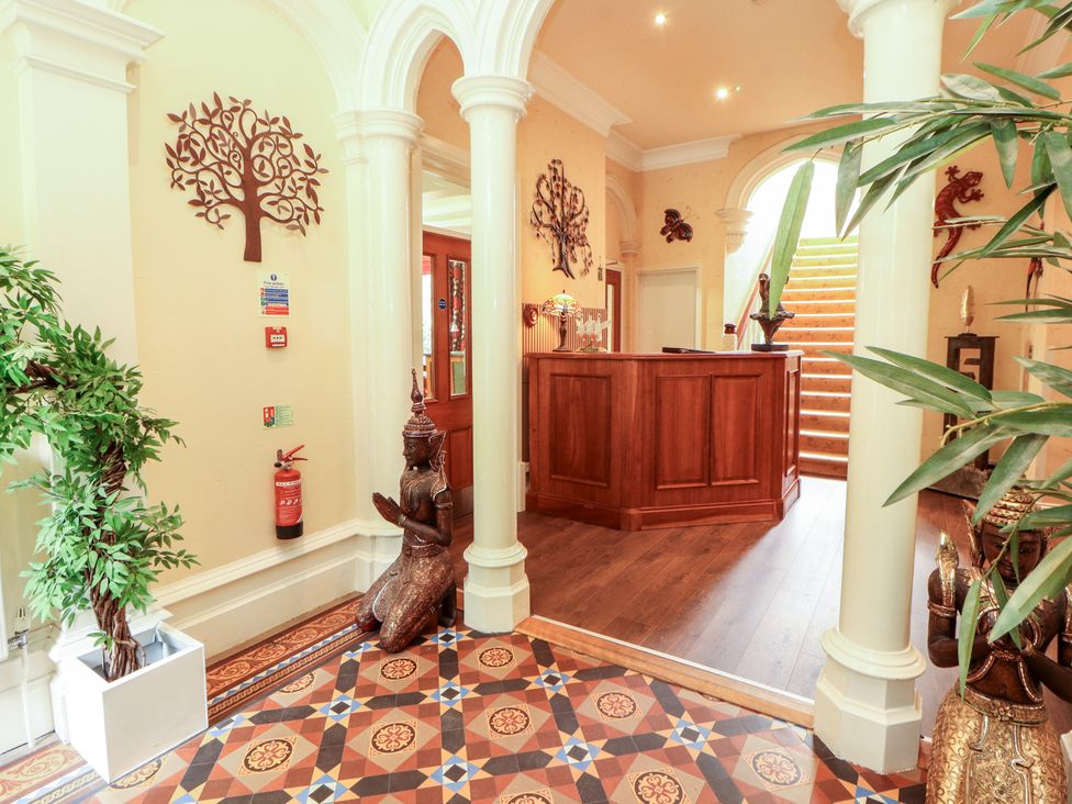 A lobby with a reception desk and plants at Eden Lodge Bardsea