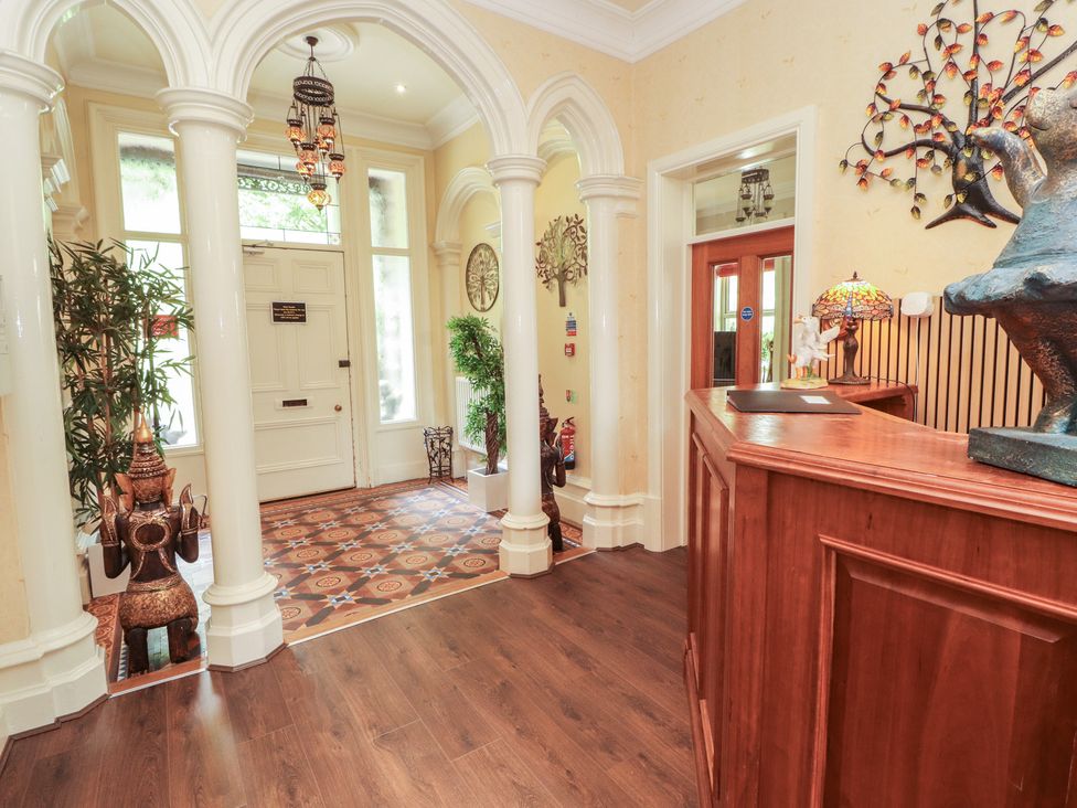 A hallway with a reception desk and decorative elements at Eden Lodge in Bardsea
