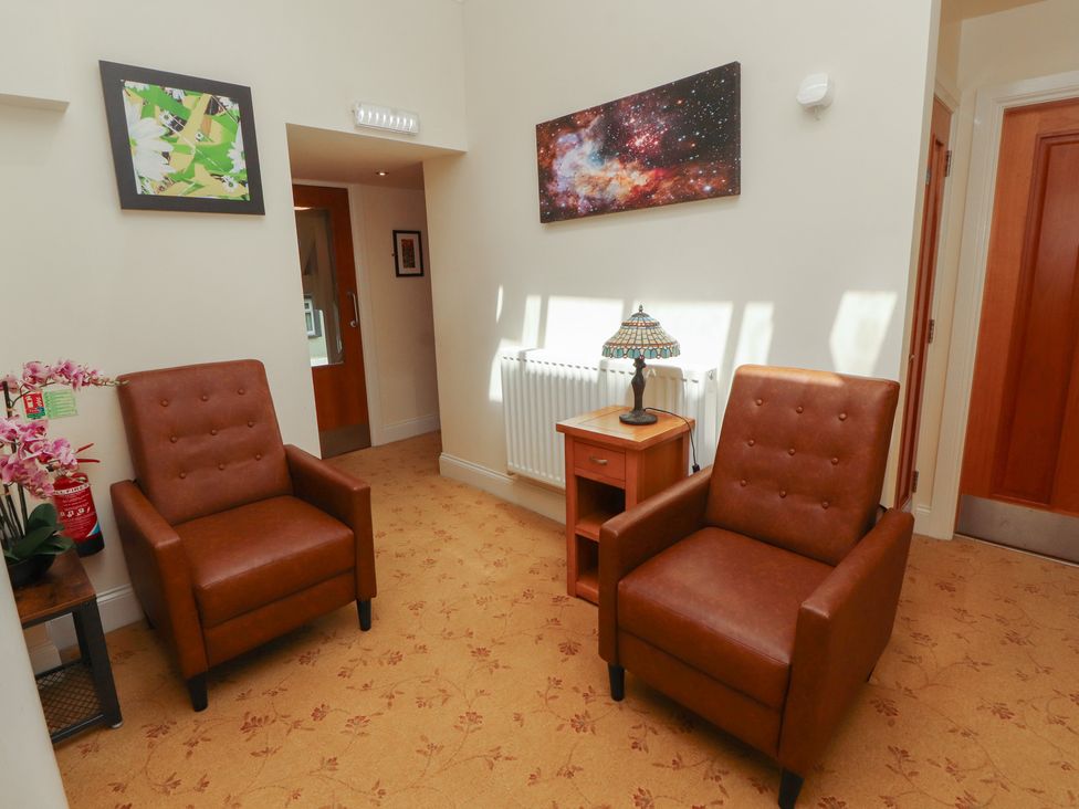 A sitting room with two chairs and a lamp at Eden Lodge in Bardsea