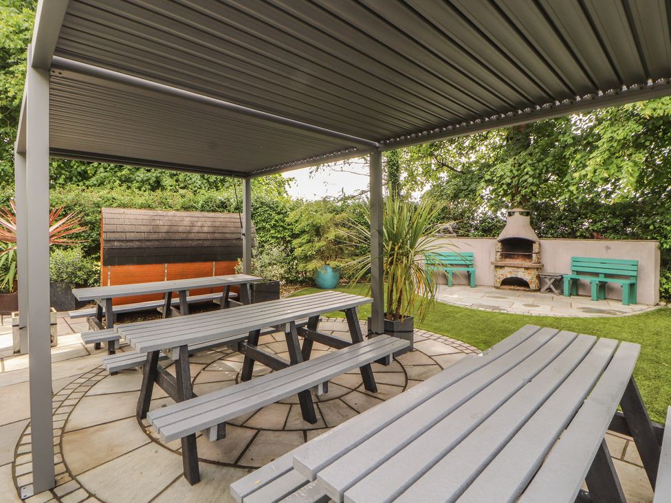 A garden with seating and a fireplace at Eden Lodge in Bardsea