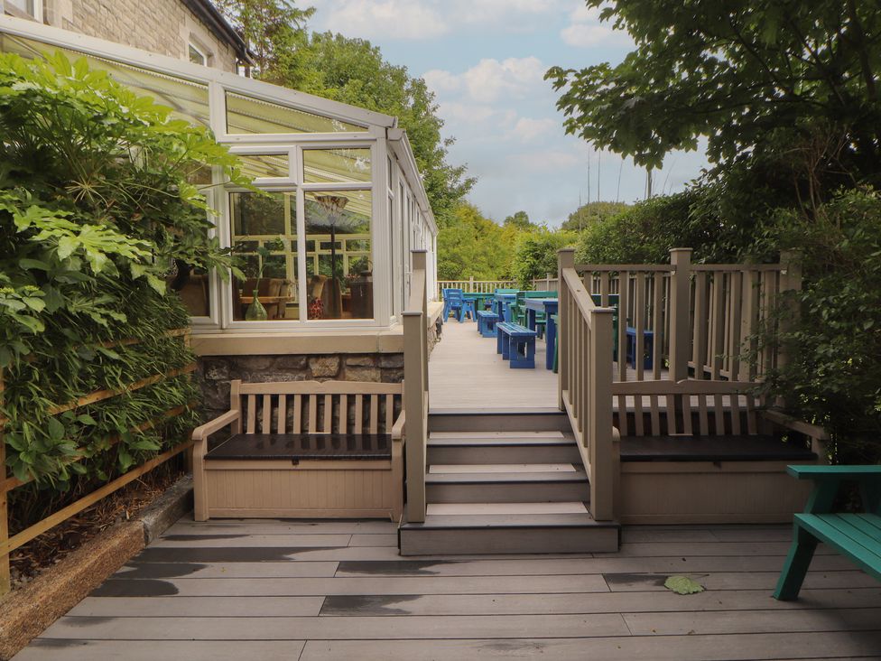 A garden with decking, benches, and steps at Eden Lodge in Bardsea
