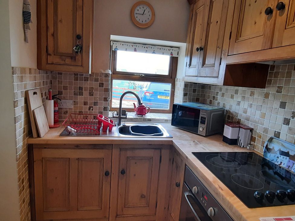 A kitchen with a sink and cabinets at 4 Cliff Cottages