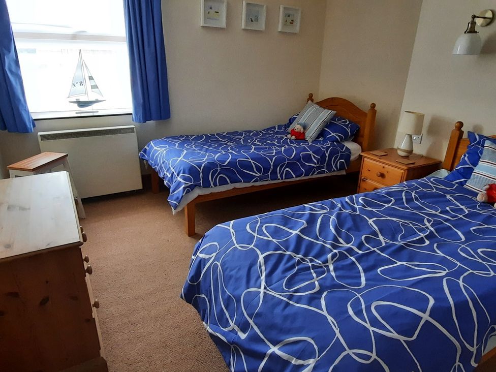 A bedroom with two beds and a dresser at 4 Cliff Cottages