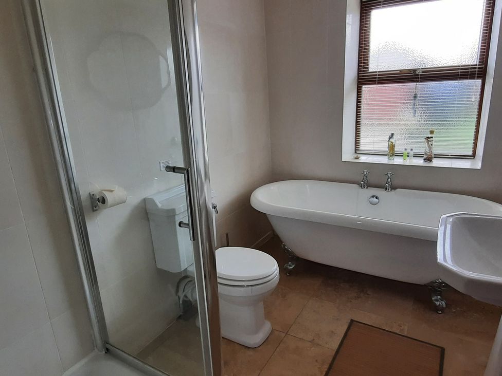 A bathroom with a shower, toilet, sink, and bathtub at 4 Cliff Cottages