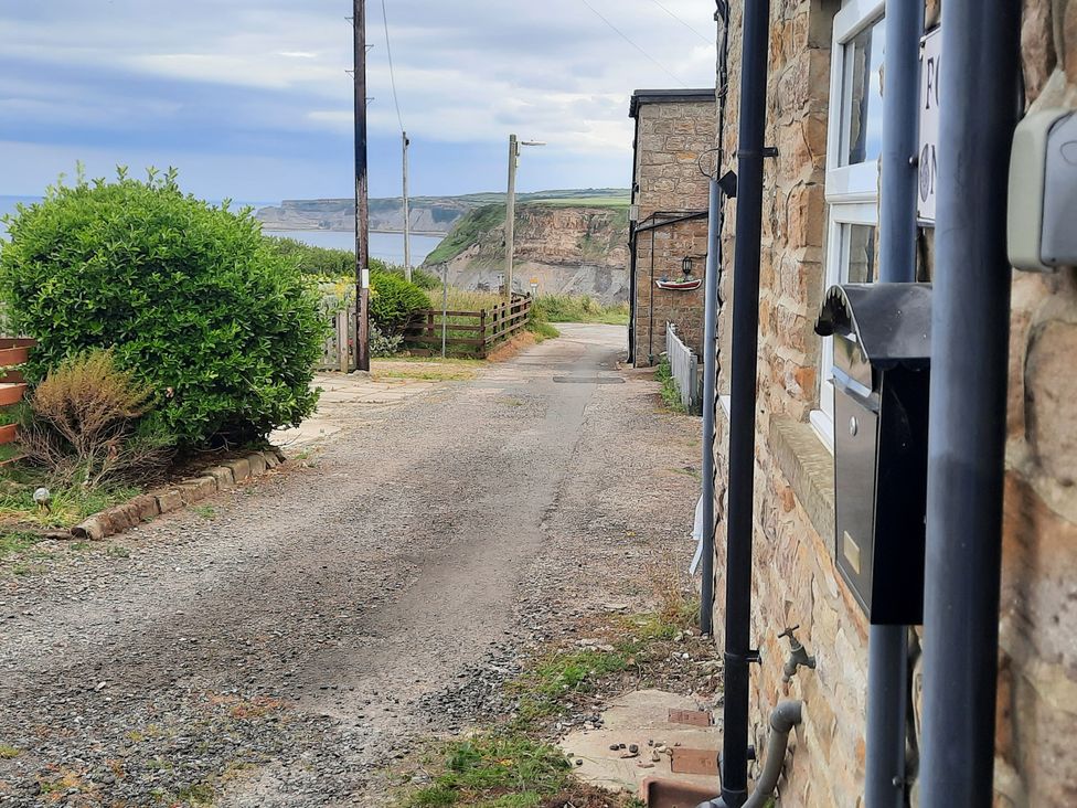 A gravel path with a mailbox and bushes at 4 Cliff Cottages in 